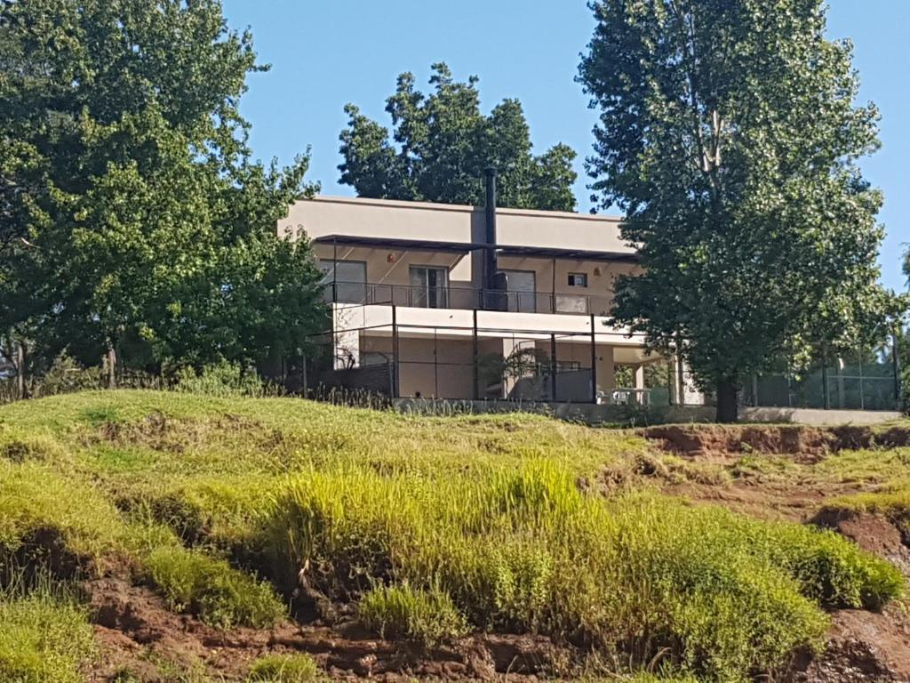 ein Haus auf einem Hügel mit Bäumen in der Unterkunft Paraíso Río in Concordia