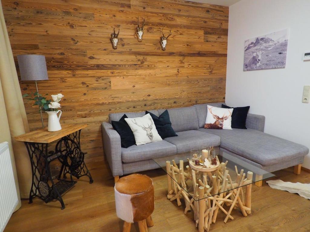 a living room with a couch and a wooden wall at MarieindenBergen - Ihre private Unterkunft in Saalbach-Hinterglemm