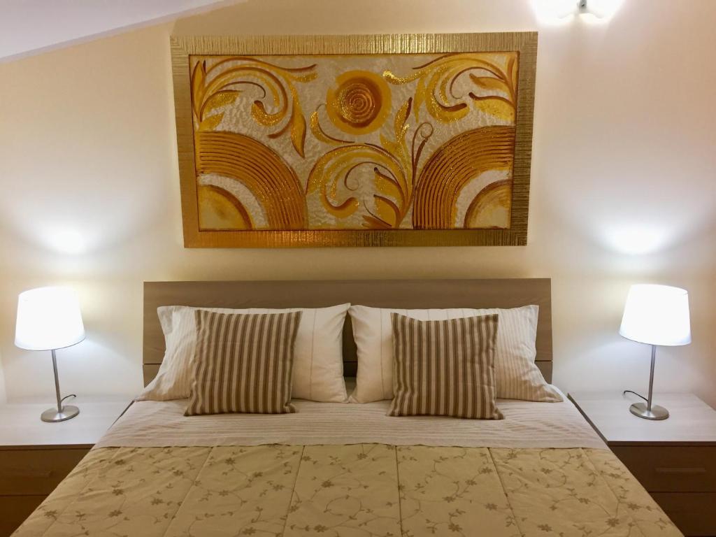 a bedroom with a bed with two lamps and a painting at villa relax in Cepagatti