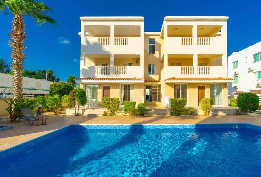 eine Villa mit einem Pool vor einem Gebäude in der Unterkunft Beautiful one bed apartment in Paphos in Paphos City