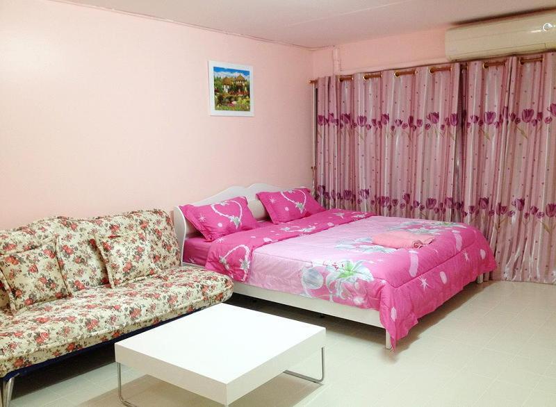 een woonkamer met een bank en een tafel bij SK Muang Thong Thani in Bangkok