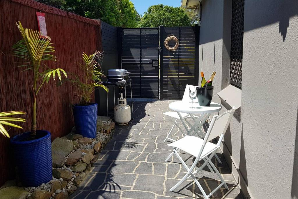 un patio con 2 sedie, un tavolo e piante di Seadreams, Maroubra a Sydney