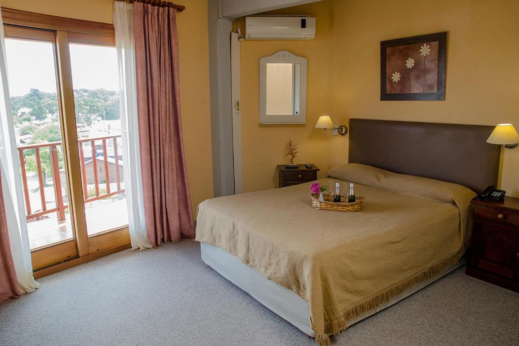 1 dormitorio con cama y ventana grande en Hostería Kaiken II en Villa Gesell
