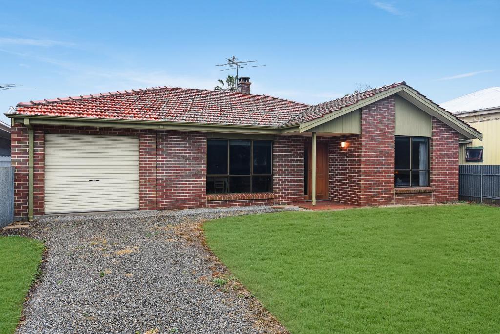 a red brick house with a lawn in front of it at Don Carmella - Aldinga Beach - C21 SouthCoast Holidays in Aldinga Beach
