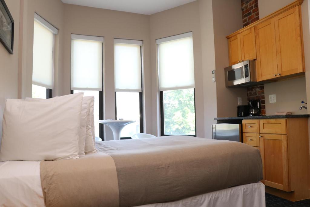 um quarto com uma cama, um micro-ondas e janelas em Furnished Studio in Downtown Boston #35 em Boston