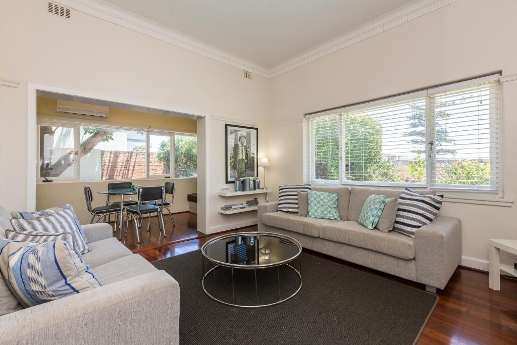 a living room with two couches and a table at Cottesloe Bel-Air Apartment in Perth