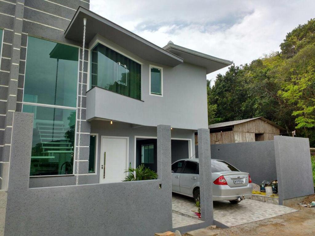 una casa con un coche aparcado delante de ella en Casa perfeita na Praia da Lagoinha, en Florianópolis