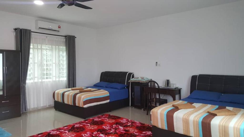 a bedroom with two beds and a ceiling fan at DD Empire Homestay in Kuala Selangor