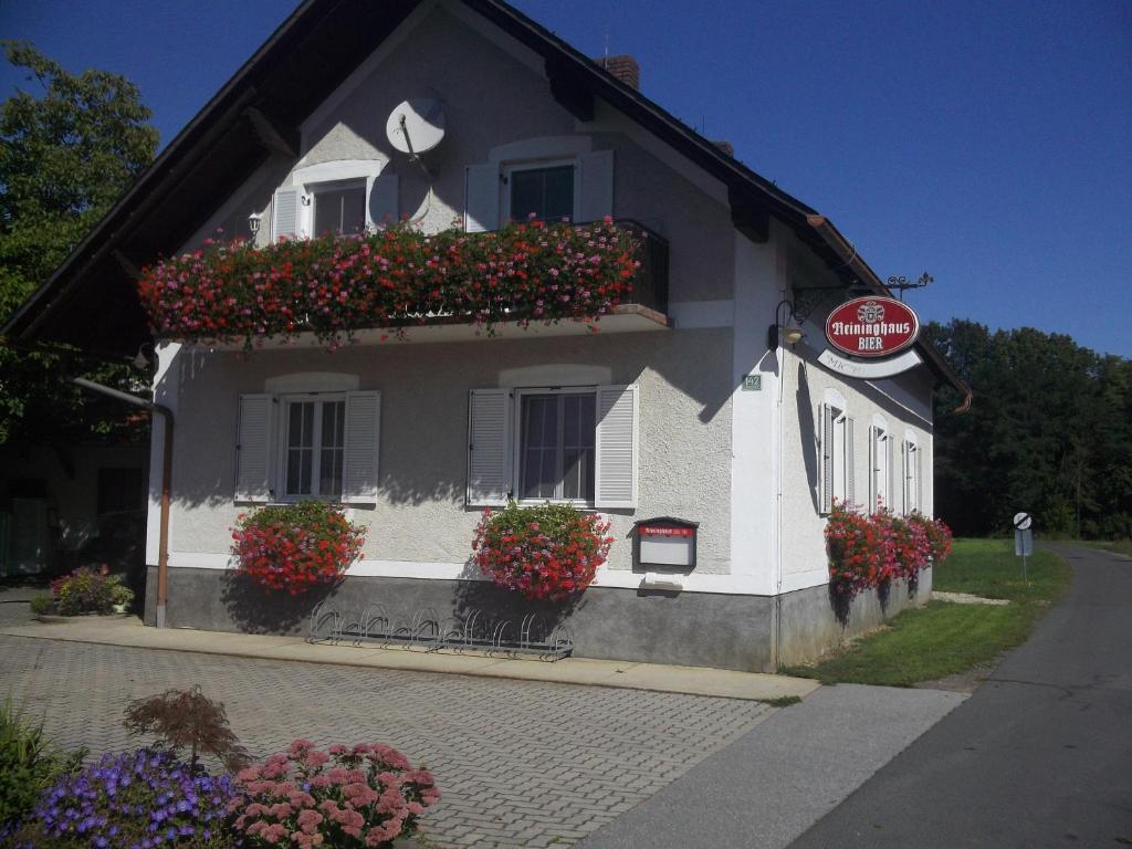 un bâtiment blanc avec des boîtes de fleurs sur les fenêtres dans l'établissement Ferienwohnung Michlwirt, à Bad Radkersburg
