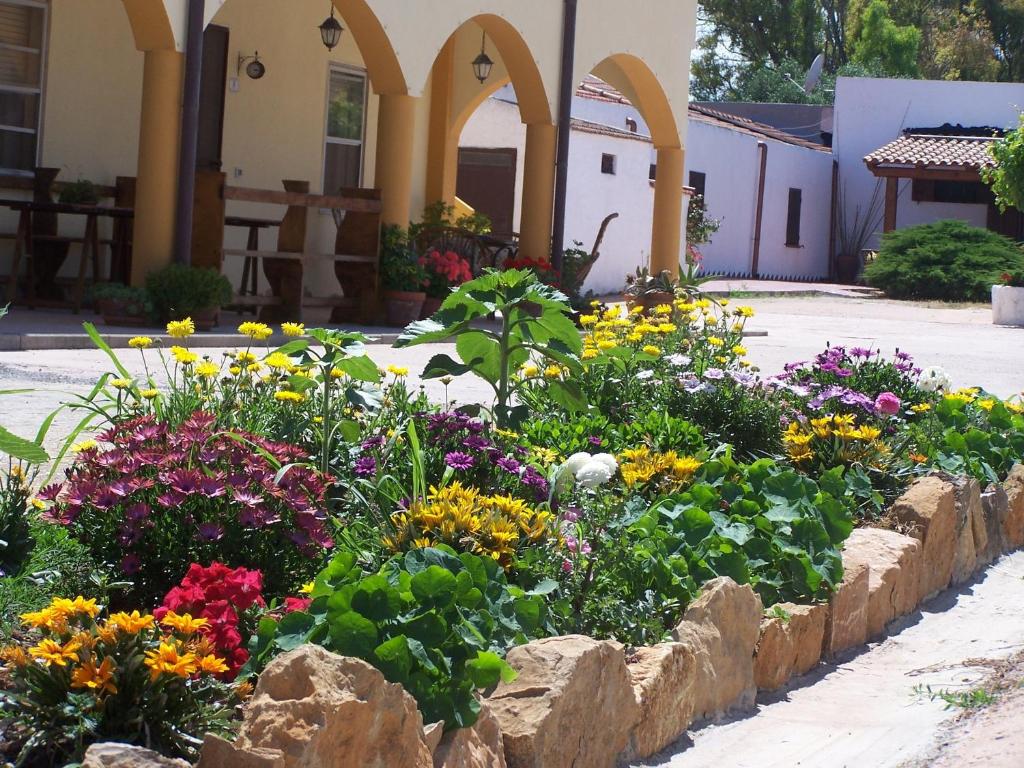 un jardín de flores frente a un edificio en Agriturismo Cuile de Molino, en Porto Torres