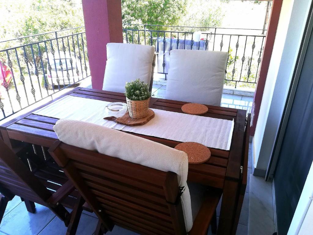 een tafel op een balkon met een plant erop bij Katerina's appartement in Nikiana