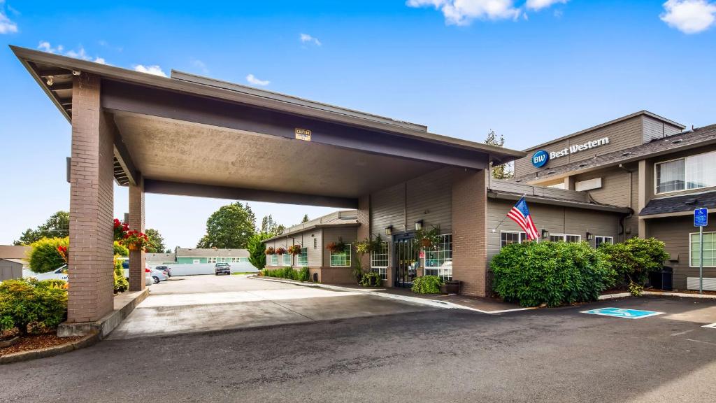 uma vista frontal de um hotel com um parque de estacionamento vazio em Best Western Oak Meadows Inn em Saint Helens
