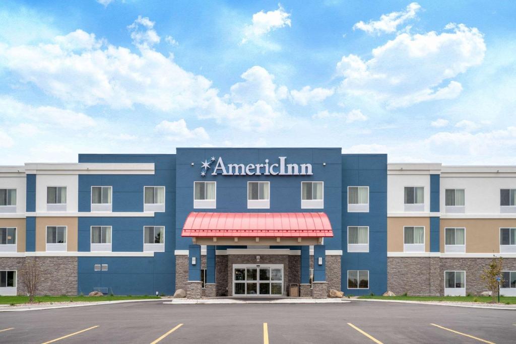 a large blue building with a sign for american inn at AmericInn by Wyndham Windom in Windom