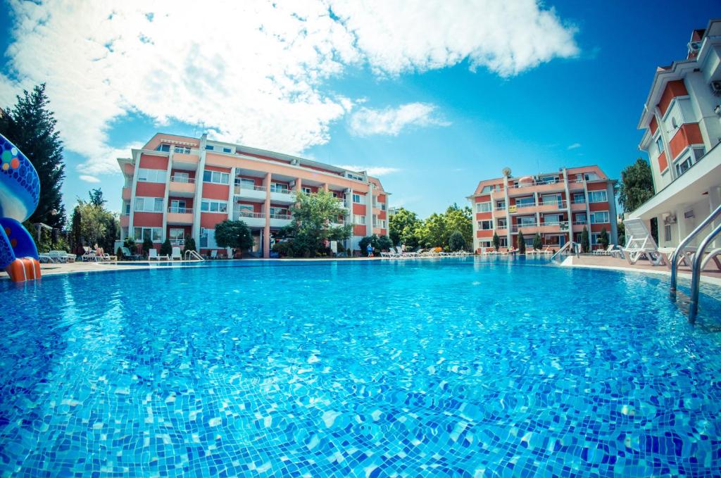 a large swimming pool in front of some buildings at Sunny Fort Apartments in Sunny Beach