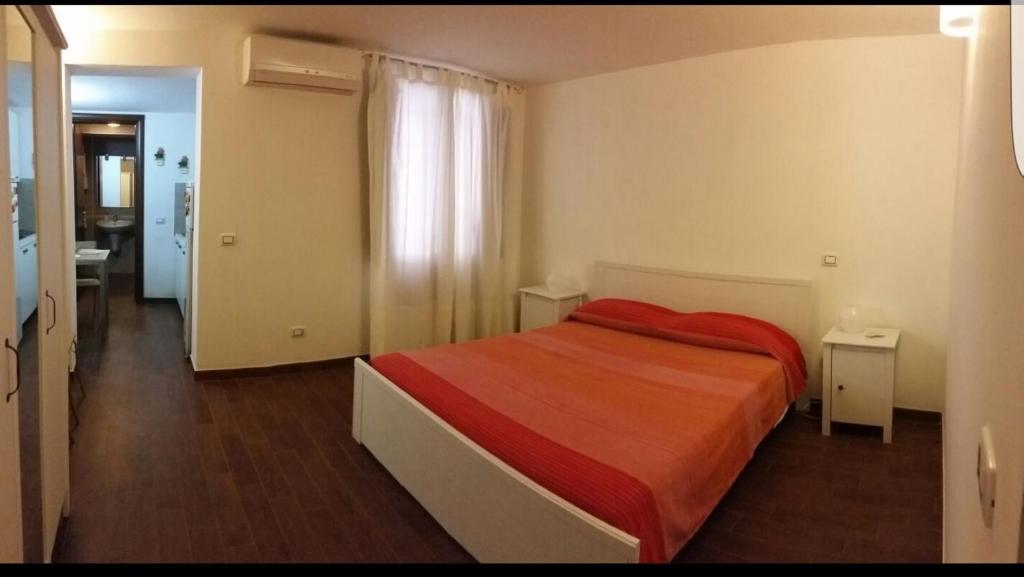 una camera da letto con un letto con una coperta rossa sopra di Home Al Rifugio a Taranto