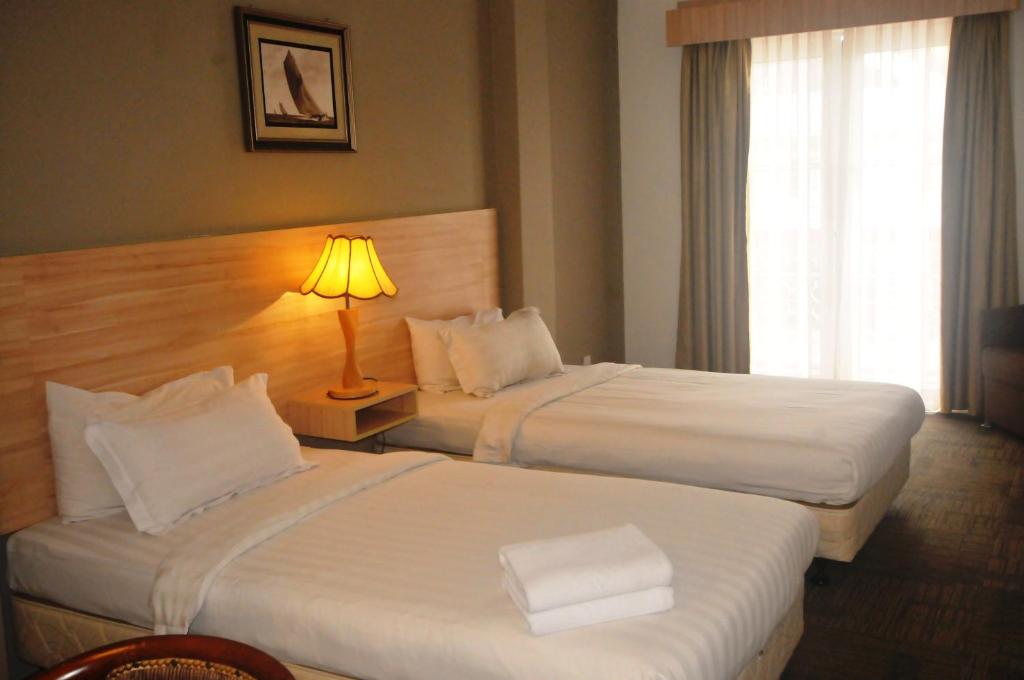 Postel nebo postele na pokoji v ubytování Prima Hotel Melaka