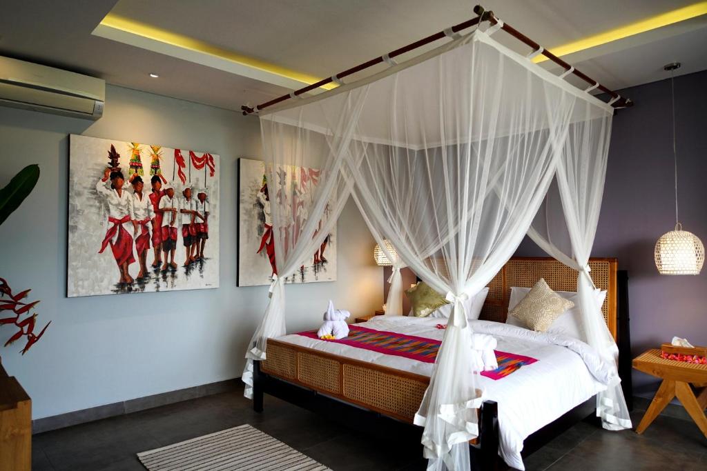Schlafzimmer mit Himmelbett und weißen Vorhängen in der Unterkunft RC Ubud Villa 3 in Ubud