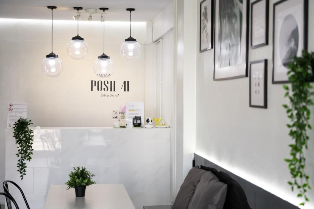 a dining room with a table and pendant lights at POSH 41 in Salaya