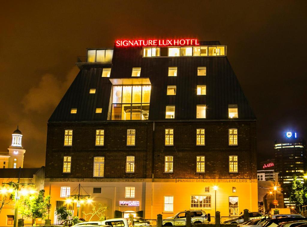 a large building with a clock on top of it at Signature Lux Hotel by ONOMO, Waterfront in Cape Town