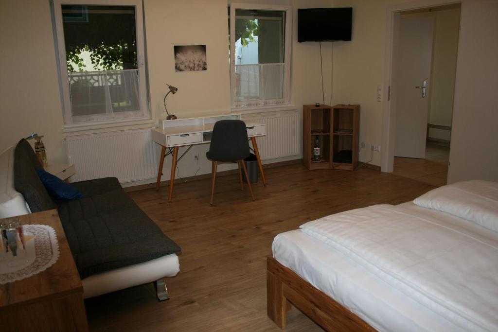 a bedroom with a bed and a desk and a table at Pension Pock in Tieschen