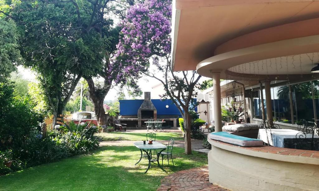 a house with a yard with a table in the grass at 3@Marion Guest House in Pretoria