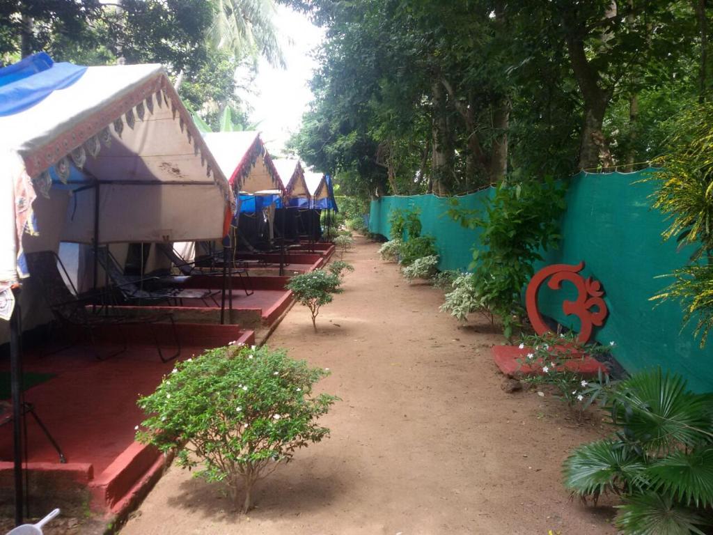 a row of tents and a fence with plants at Nature Camp Bhitarkanika Retreat in Righāgarh