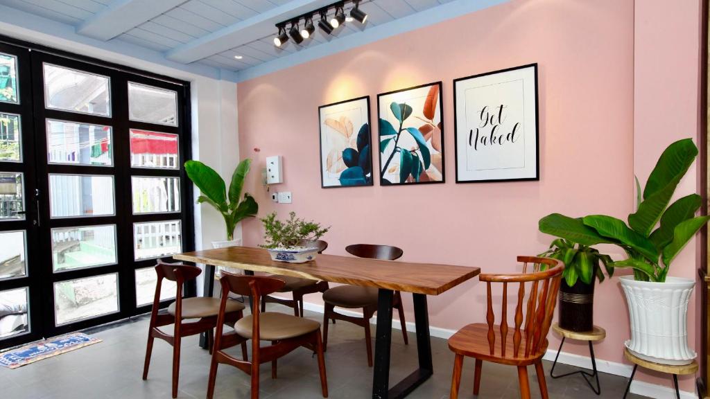 a dining room with tables and chairs and a mural on the wall at Sleep Box Hostel Phú Quốc in Phú Quốc