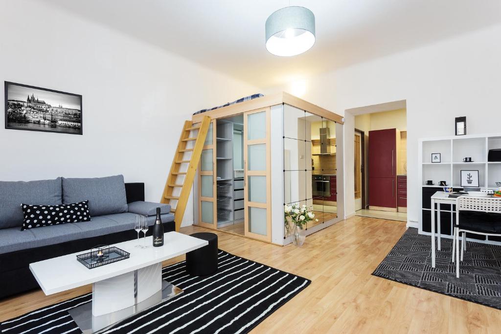 uma sala de estar com um sofá azul e uma cozinha em Stylish apartment on riverside em Praga