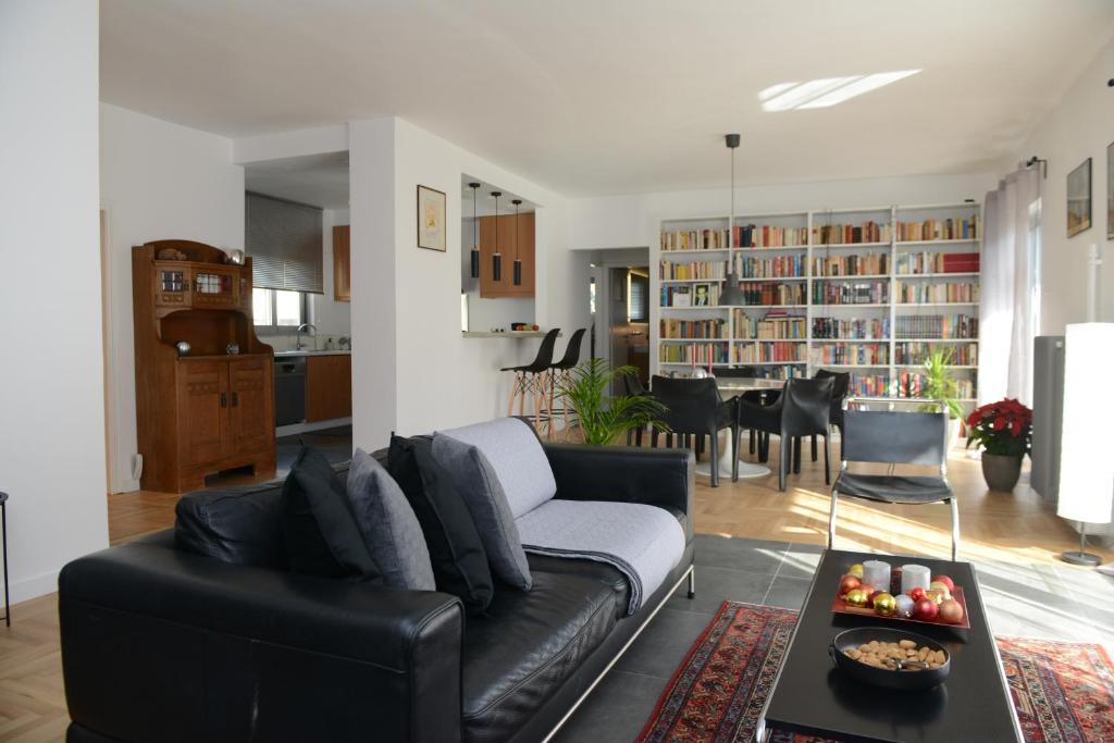 sala de estar con sofá de cuero negro y mesa en Boutique Apartment in Chalandri, en Atenas