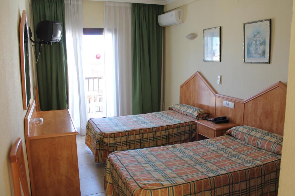 a hotel room with two beds and a window at Hotel Las Vegas in Benidorm