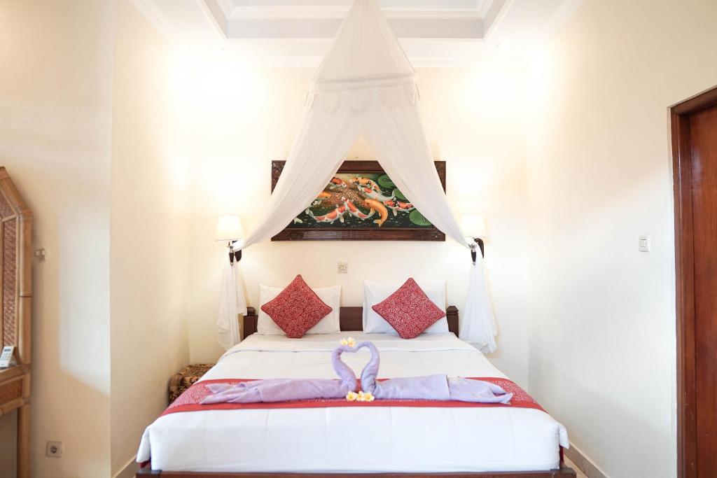 a bedroom with a bed with a canopy at Raka House Accommodation in Ubud