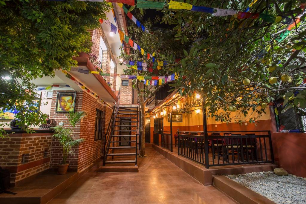 a corridor of a restaurant with trees and flags at Gurung's Home in Kathmandu