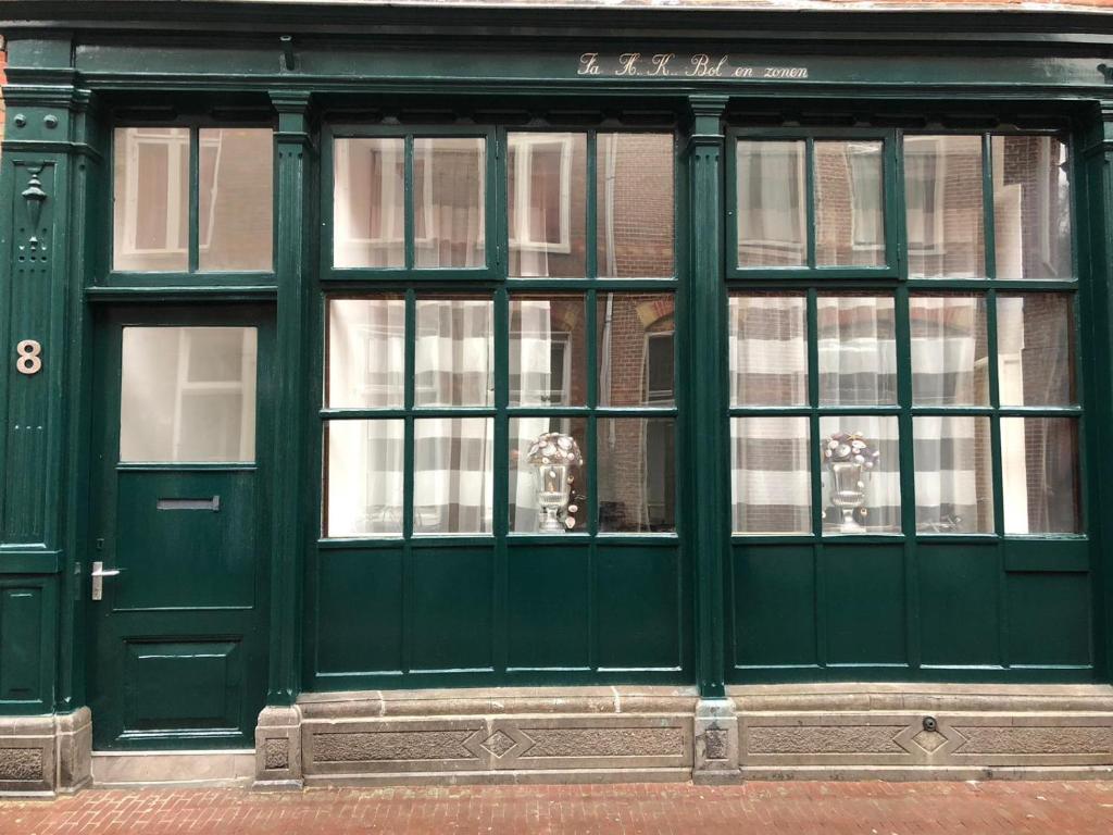 eine grüne Tür eines Ladens auf einer Straße in der Unterkunft Prinsenstraat 8 in Groningen