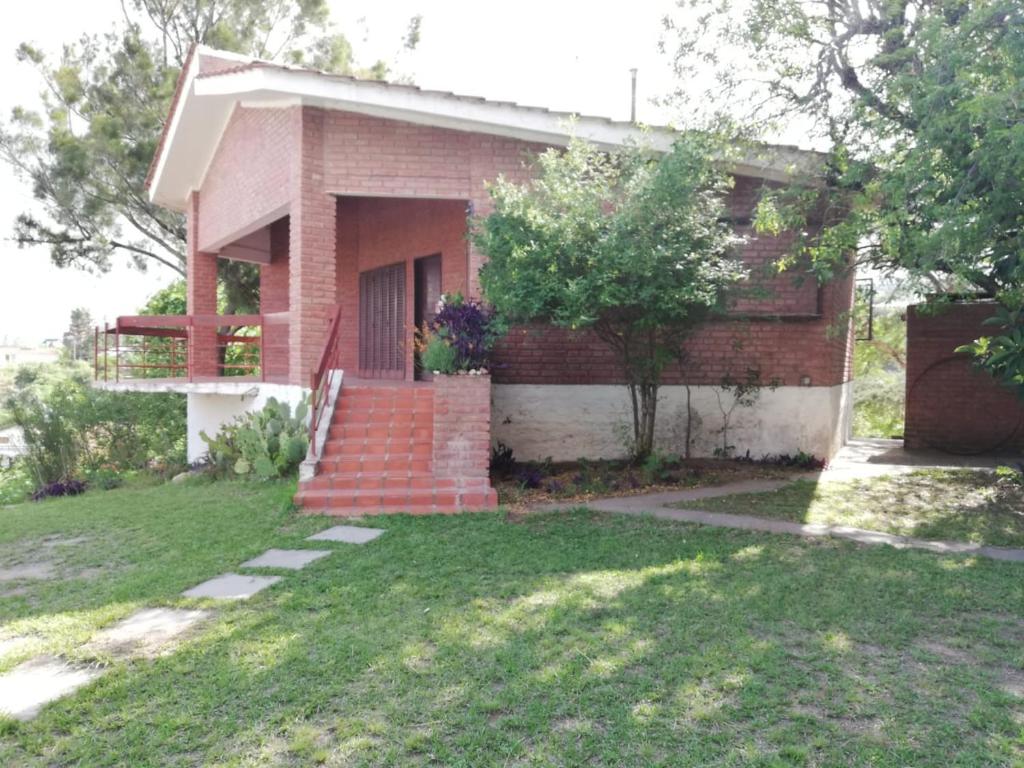 una casa de ladrillo con una escalera en el patio en Casa Lago Azul en Córdoba