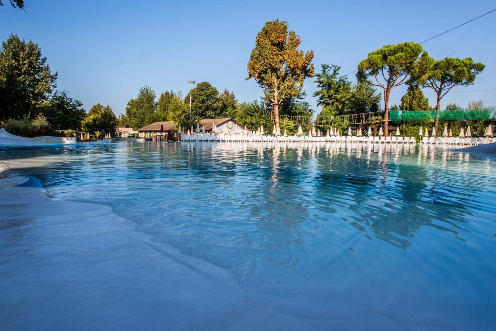 ヴァレッジョ・スル・ミンチョにあるHotel La Diga Altomincioの木々を背景にした大きな水のプール