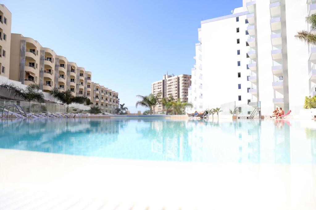 プラヤ・パライソにあるLuxury apartment in Playa Paraisoの一部の建物の前に大きなスイミングプールがあります。