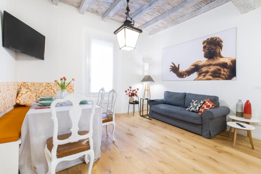 GetThekey San Vitale Apartment في بولونيا: غرفة معيشة مع طاولة وأريكة