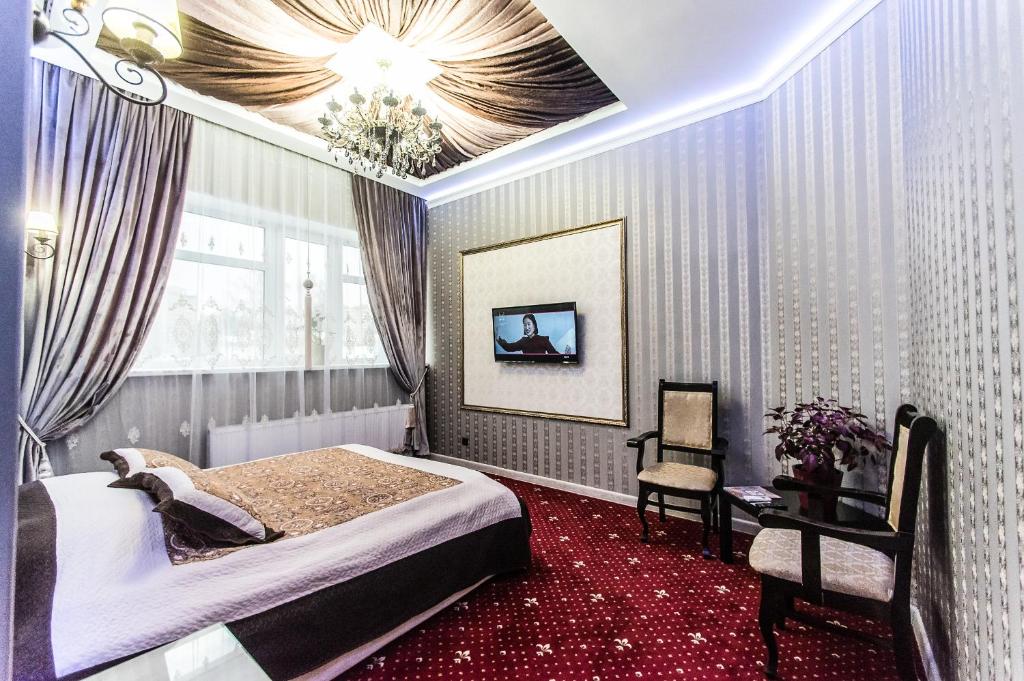 a bedroom with a bed and a chandelier at Hotel Rai in Ivanovo