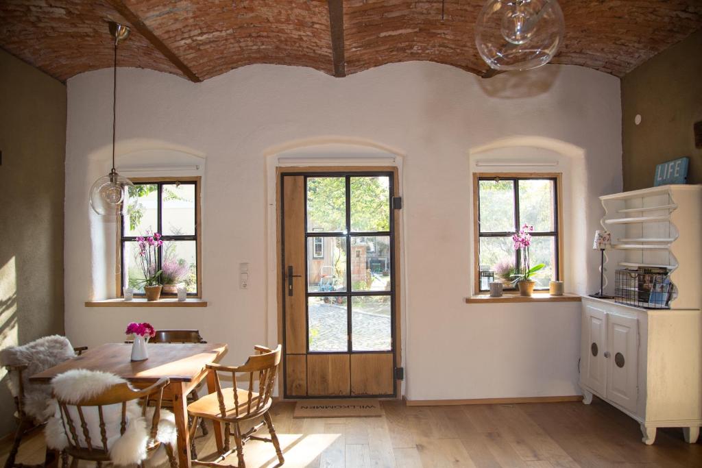 a dining room with a table and some windows at Exklusive Ferienwohnung Bad Fischau in Bad Fischau