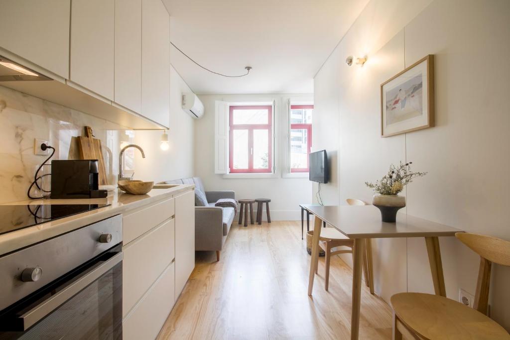 eine Küche und ein Wohnzimmer mit einem Tisch und einem Esszimmer in der Unterkunft Oporto Sweet Home IV in Porto