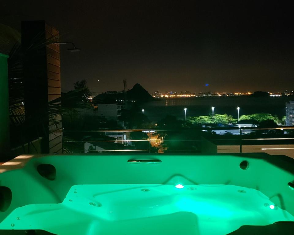a green pool table on a balcony at night at Mansão & Loft Exclusivo Vista Mar in Niterói
