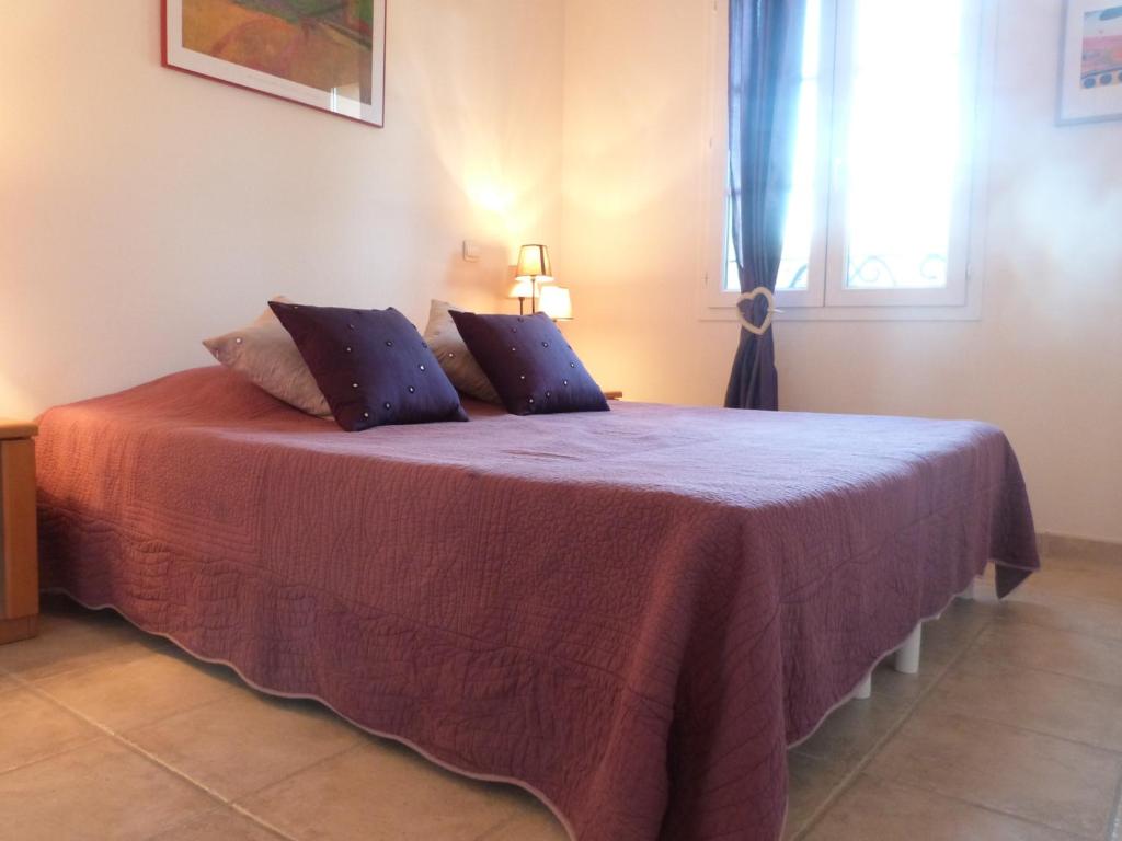 ein Schlafzimmer mit einem Bett mit einer lila Decke in der Unterkunft GASLIND - Golfe de St-Tropez - Mazet dans domaine privé avec piscine in Gassin
