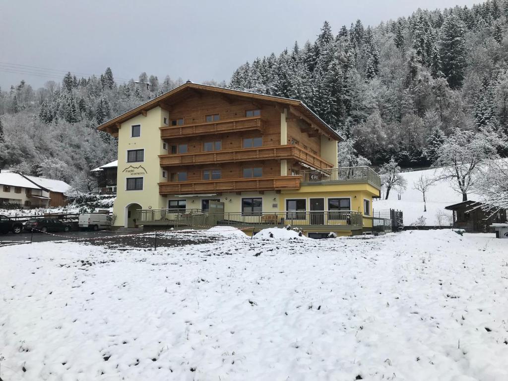 a large building in the snow in a field at Fiechtl Apartments in Stumm