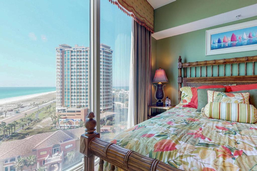 a bedroom with a large window with a view of the ocean at Portofino #1103 in Pensacola Beach