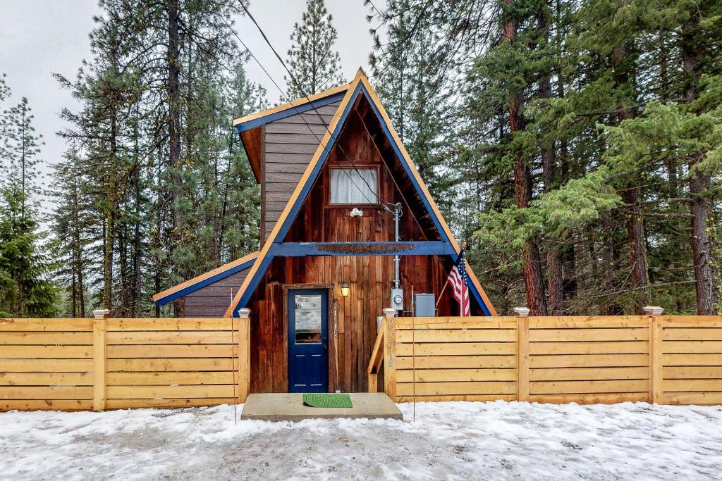 a small cabin with a blue door in the snow at Copper Top Chalet in Leavenworth