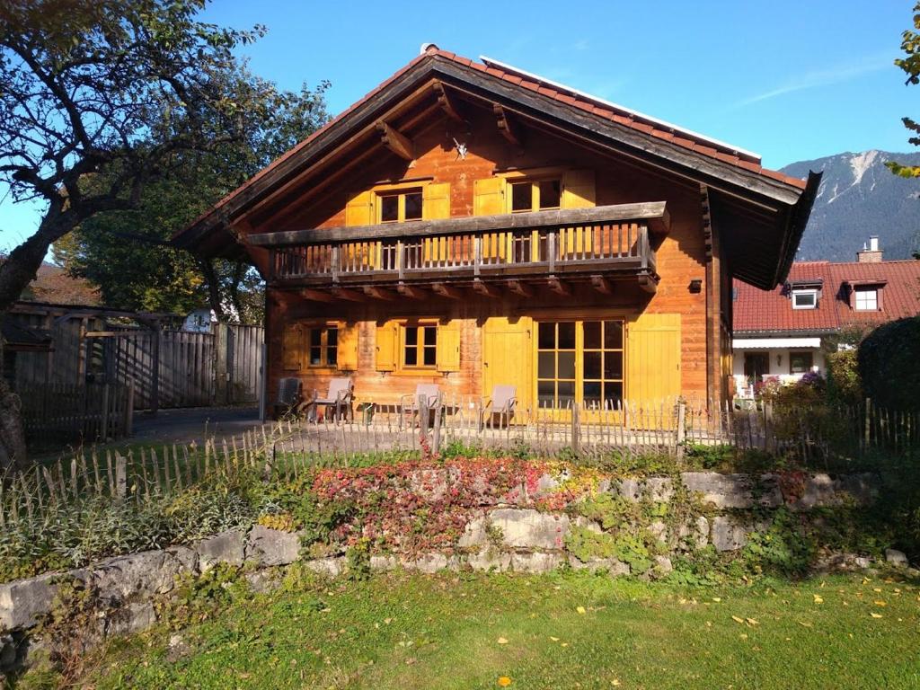 ein großes Holzhaus mit Balkon oben in der Unterkunft Chalet Königsstand in Garmisch-Partenkirchen