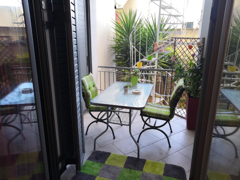 a patio with a table and chairs on a balcony at Barbara's appartment in Athens