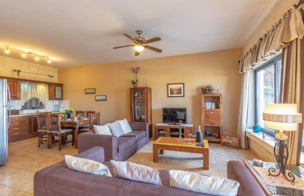a living room with a couch and a table at Ghajn Damma in Xagħra