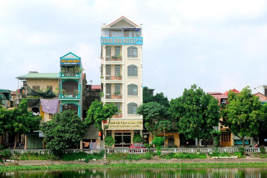 un edificio blanco alto junto a un río en Xuan Hoa Hotel, en Ninh Binh