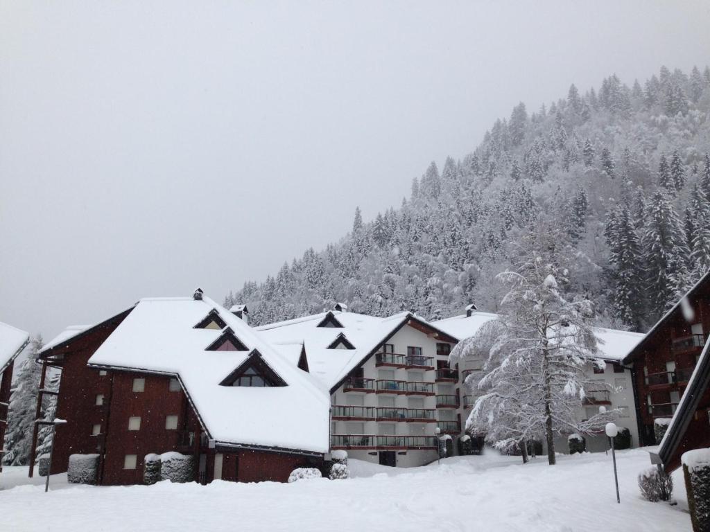a building covered in snow with a mountain in the background at L'Enclave in Les Contamines-Montjoie
